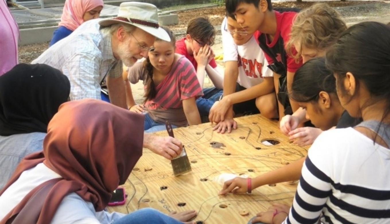 Caption:Edgerton Center instructor Ed Moriarty and students from Team Lite work on a surface that will display a matrix of red, green, and blue LEDs.