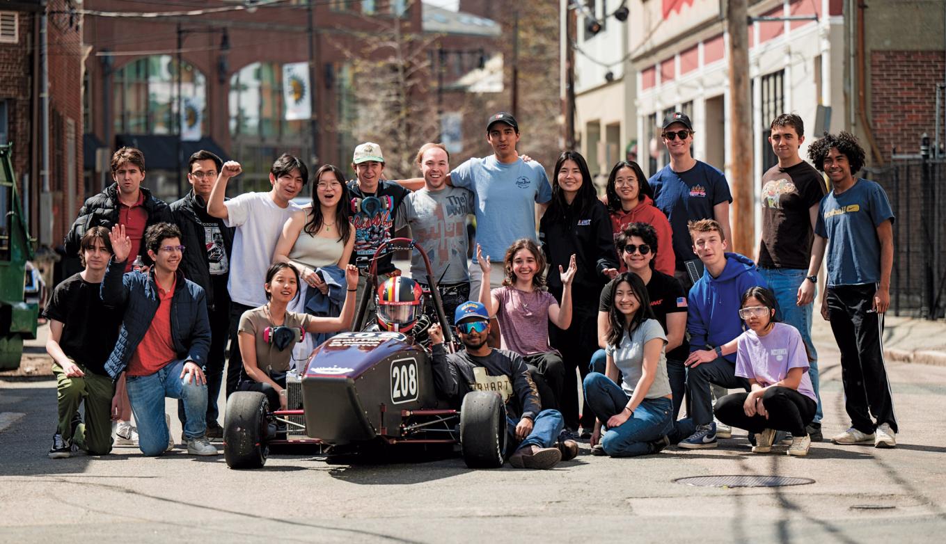 2024 MIT Motorsports Team with their electric race car at an Edgerton Center Showcase