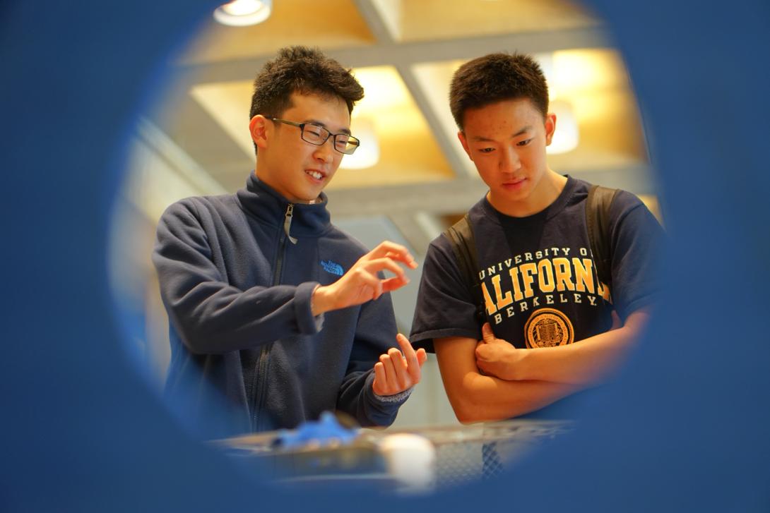 Toya Takahashi '26, Arcturus Systems Engineering Lead sharing their autonomous boat with a student visitor