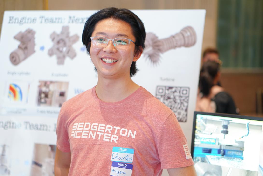 Charles Yong ’25 in front of the Engine Team poster